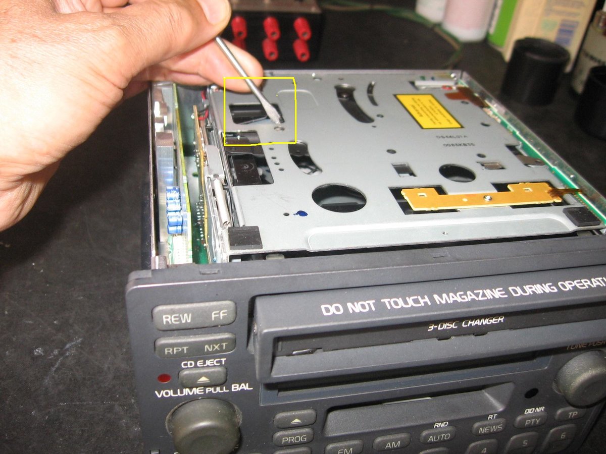 with a screwriver turn the metal gear toward you in order to open the CD magazine tray. Open tray fully