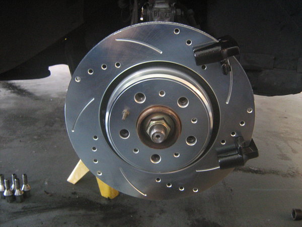 004: New 302mm rotor and caliper bracket, with black engine block paint drying.