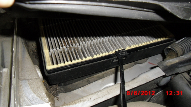 Mine already had a retainer and filter. Remove the old Volvo brand cabin air filter by pushing on the slot with a flat screwdriver and lifting up on the tab.