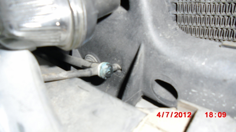 Old 3-way valve behind right side headlight, leaking profusely onto a sensor beneath.