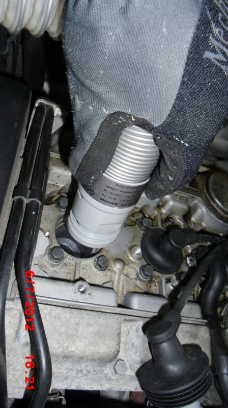 Using the shop vac to suck out debris before removing the old spark plug. I also vacuum after removing the plug as a precaution.