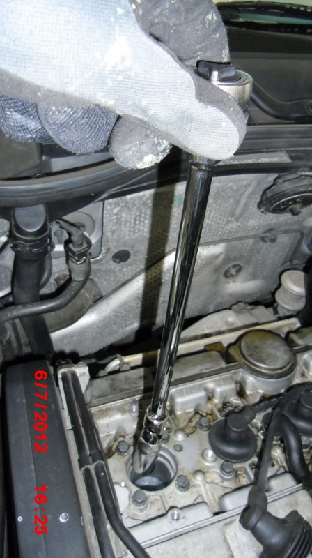 Removing old spark plug at #1 cylinder using ratchet, extension, and flex-joint. Turn the spark plug socket slowly to avoid stripping threads.