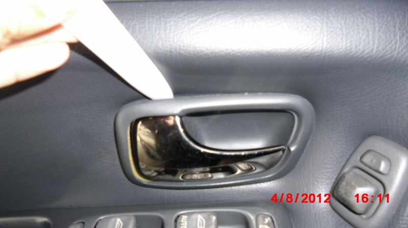 Popping off door handle trim of a 1998 V70 XC using a bone tool. Follow the order in the factory instruction.
