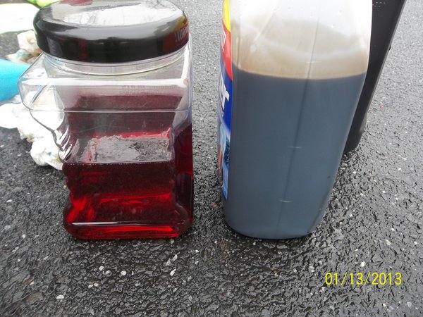 DIrty oil in plastic jug on right and clean oil in clear jug on left