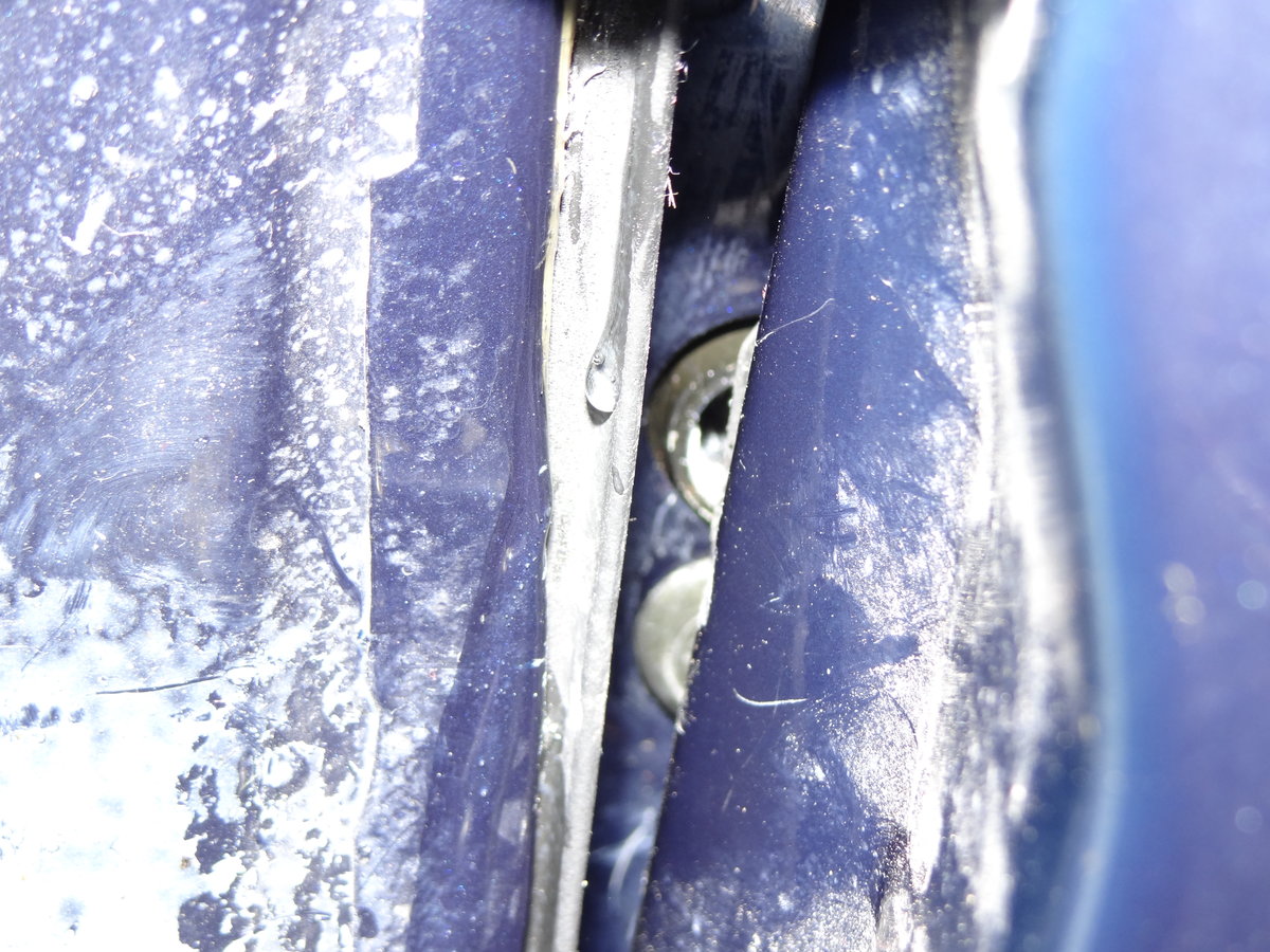 Here you can see the 2 holes in between the doors. the holes are on the rear of the driver's door. this pic is taken from the back seat behind the driver's seat looking into the door seam. ** Notice the lower hole has a torx screw in it but the top hole doesn't. That's because the top hole is not a hole, it's the actual latch. This is the part where you put in the smaller screwdriver on and BANG IT with the rubber mallet. and the door should pop loose!