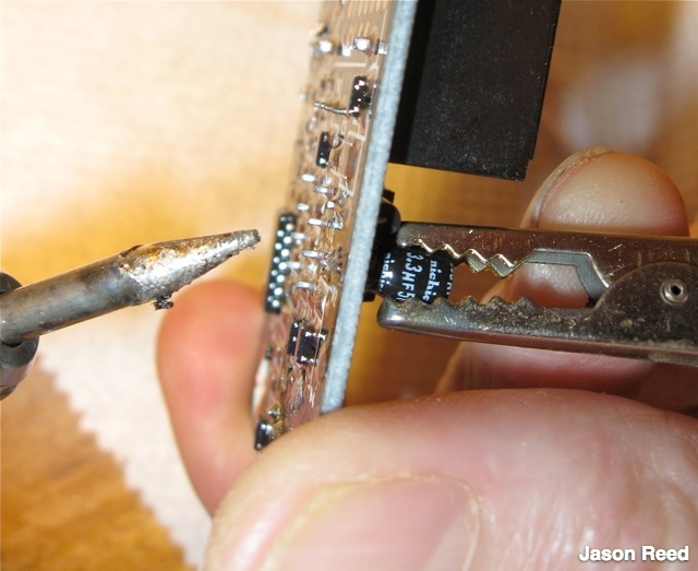 Desoldering the old electrolytic caps from the board