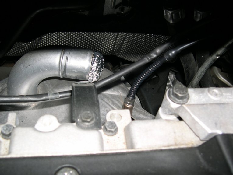 heat shield on exhaust manifold with oxygen sensors coming out. plugged hole from preheating pipe with wad of aluminum foil.