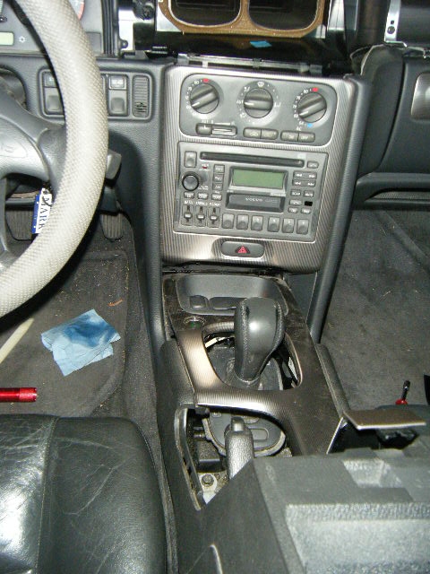 Slowly easing the lower center console assembly up and out...the way to work this was to tilt up the back end and then gently pull towards the back of the car with the back end still up, as there are some plastic tabs towards the front which help secure the rest of it all in place (aside from the 2 screws originally removed)