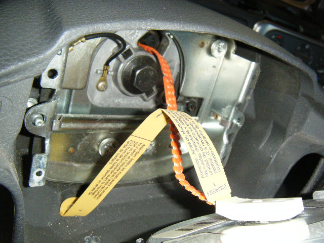 I'll probably goof up the technical terminology for this, but suffice to say the white tab with the yellow and orange straps is the connector for the airbag in the steering wheel...