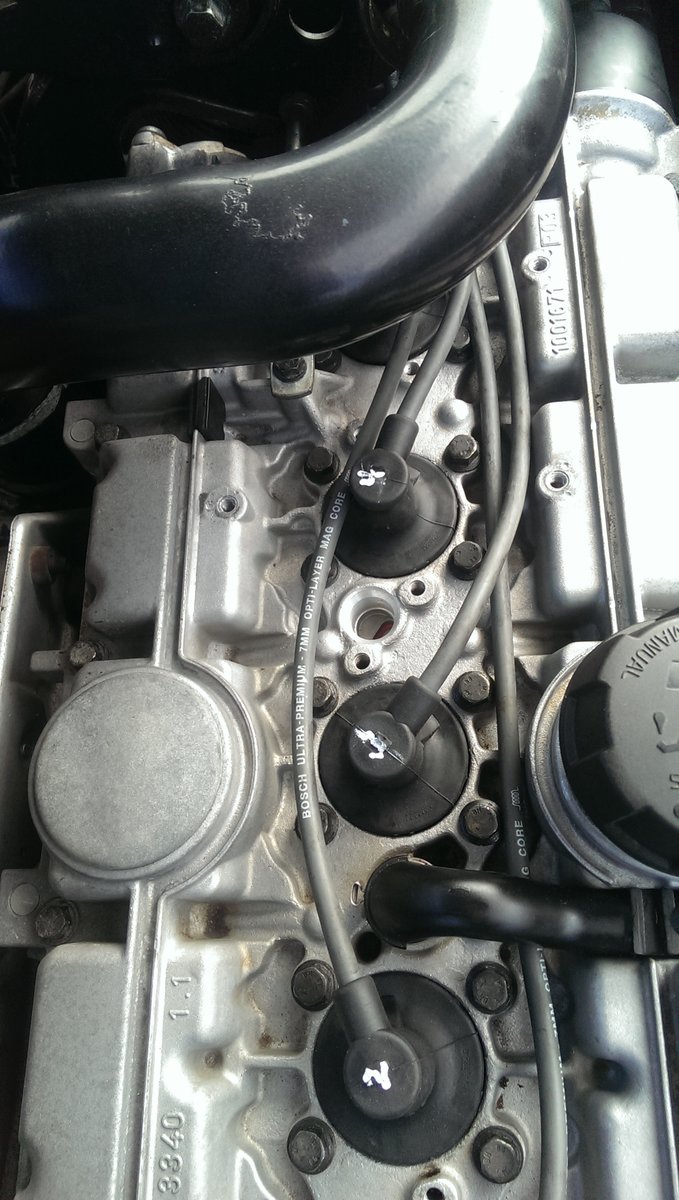 Mystery hole in cam cover between plugs 3 and 4. It's flanked by 2 threaded bolt holes. Anyone?