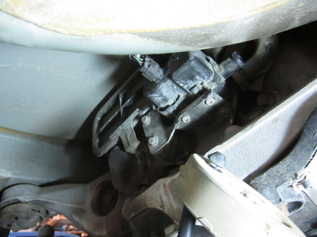 1 of 3 views of pump. Positioned in-front of spare wheel well and above rear axle