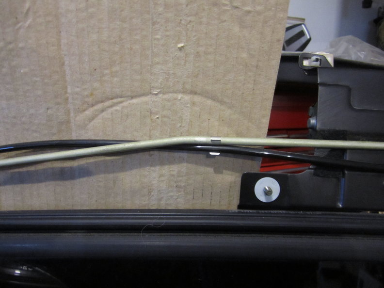 LH front showing cable and small black drain(?) with clip and front roof mount