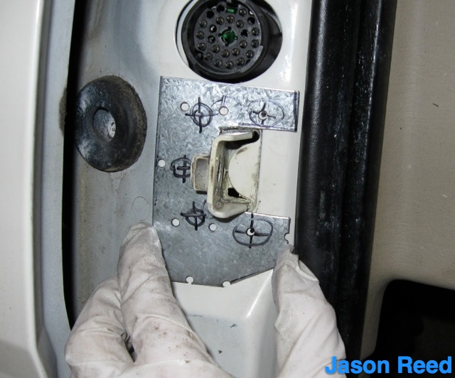 Hold steel against door in preparation for marking holes.jpg