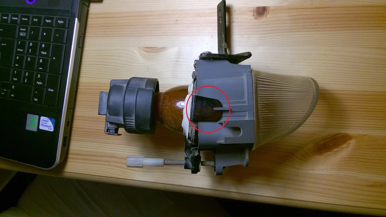 The fog lamp with the adjuster down, and the black tab circled.