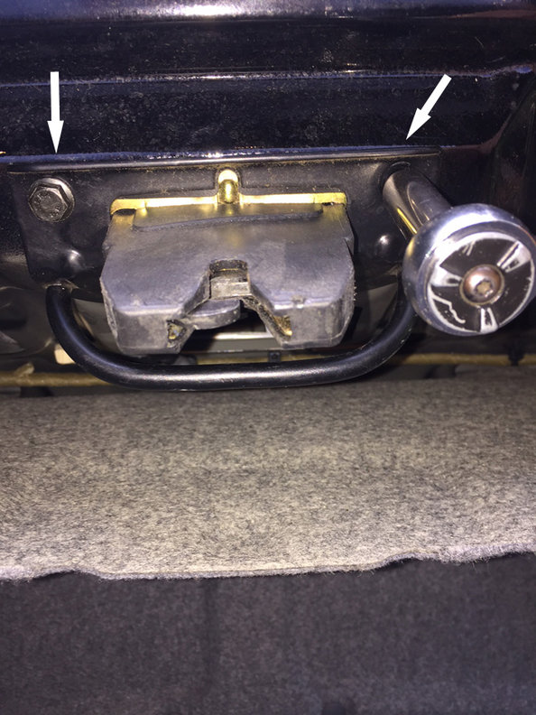step 3 - move to the center and remove the 3 bolts (10 mm) that secure the pull bar to the latch and mount the latch to the trunk. Two bolts visible here (arrows), the third is up along the inside of the trunk.