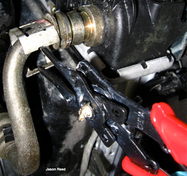 Snap ring pliers in action on the oil line clamp