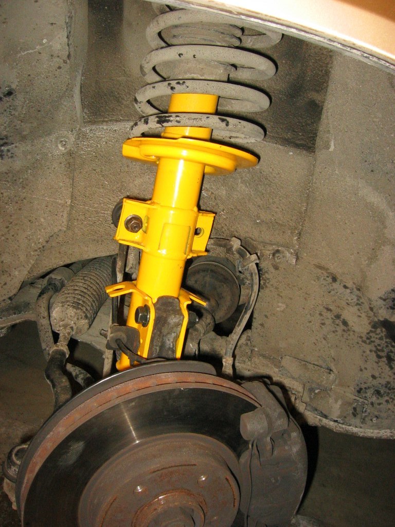 Maneuver the strut back into where is belongs from under the wheel well. (is it just me or is the rust growing on the brake disc?  It took me so long to get to this part!)  Put in the lower retaining nuts and bolts (use new ones) and tighten the sway bar link nut (pain in the a$$).  Don't forget the ABS cable.