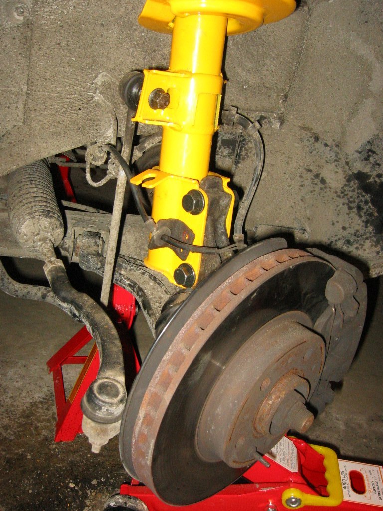 Jack the suspension up and tighten the 3 upper mounting nuts (21 ft/lbs) to secure the suspension in place.  Use new nuts for that too.  When you're done it should look like this and everything should be secured in place.  Hopefully....<br /><br />You're all DONE!! YAY!  Except that you have 1 more side to do you're all done!  Hehe.<br /><br />Take a short drive after you're ALL done.  Drive around the block to see if there is anything wrong.  Remember to take the car in for alignment as soon as possible.  You HAVE to do this because the alignment is now wrong.  Don't forget about this!<br /><br />Now you can go brag about this to your friends and tell them "I changed the struts on my car, piece of cake!"  Don't forget to return whatever you have rented!