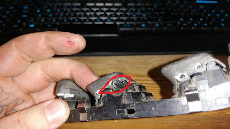 place the staple behind the button and under its collar, then use a pair of plyers to bend it over the plastic hinges, dont tighten it to much, as you want to have some movement, and as little friction against the plastic as possible