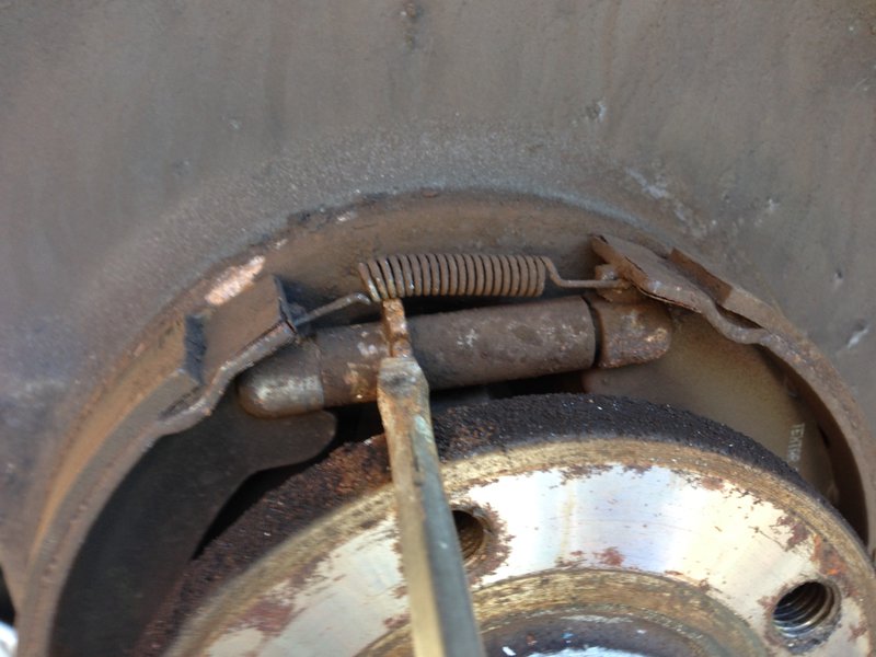 Close up of parking brake adjust. Lift screw up to tighten, through hole in rotor face.