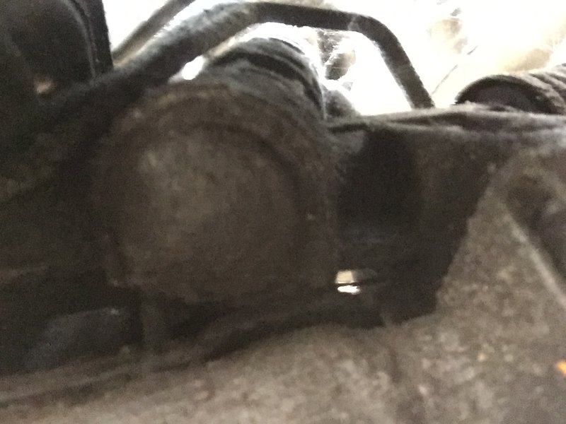 Same car (1997), the rounded cap. I got this pic by reaching under the car and using a front-facing camera on a cell phone. No need to jack up the car.