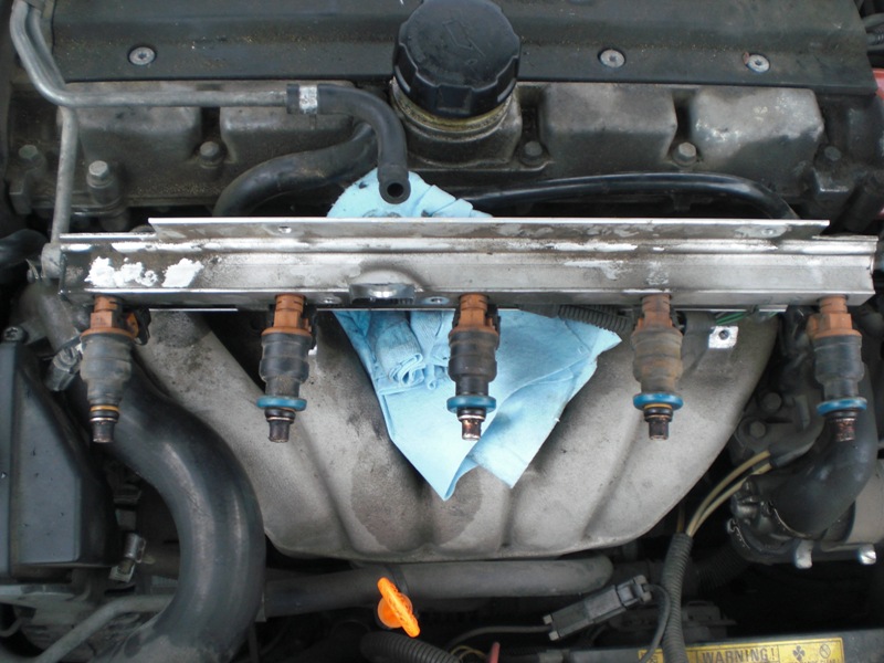 A look at the injectors. They are D-I-R-T-Y. Don't worry, I cleaned them up the best I could before I put them back in. Also, you can see where the gas stained the manifold. The leak pooled at the top of the manifold and leaked down to cause that stain.