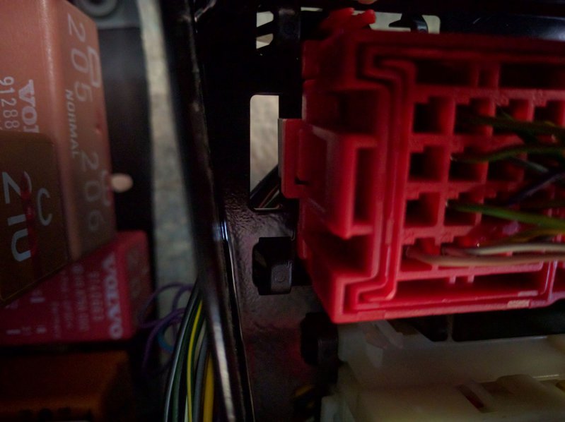 Small black tangs both sides of the red connector coming through the black metal mounting plate. Not the square tang, but the smaller hook looking tang along the side.