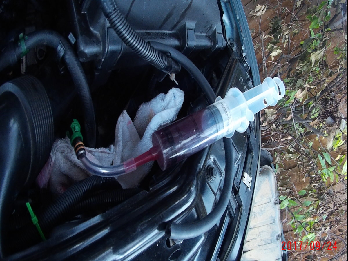 Using a syringe to add small quantities of fresh fluid to wash filings back to the newly drilled hole