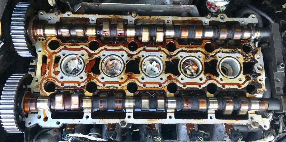 BEFORE: Top side of cylinder head with camshafts in place, before cleaning.