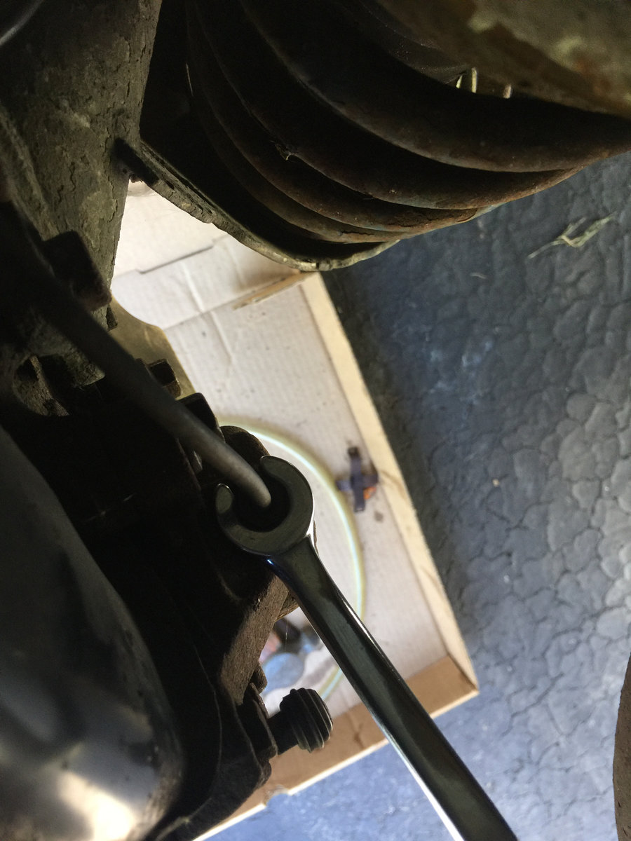 Just remove at caliper. If nut freezes, spin caliper off rather than breaking hard line.