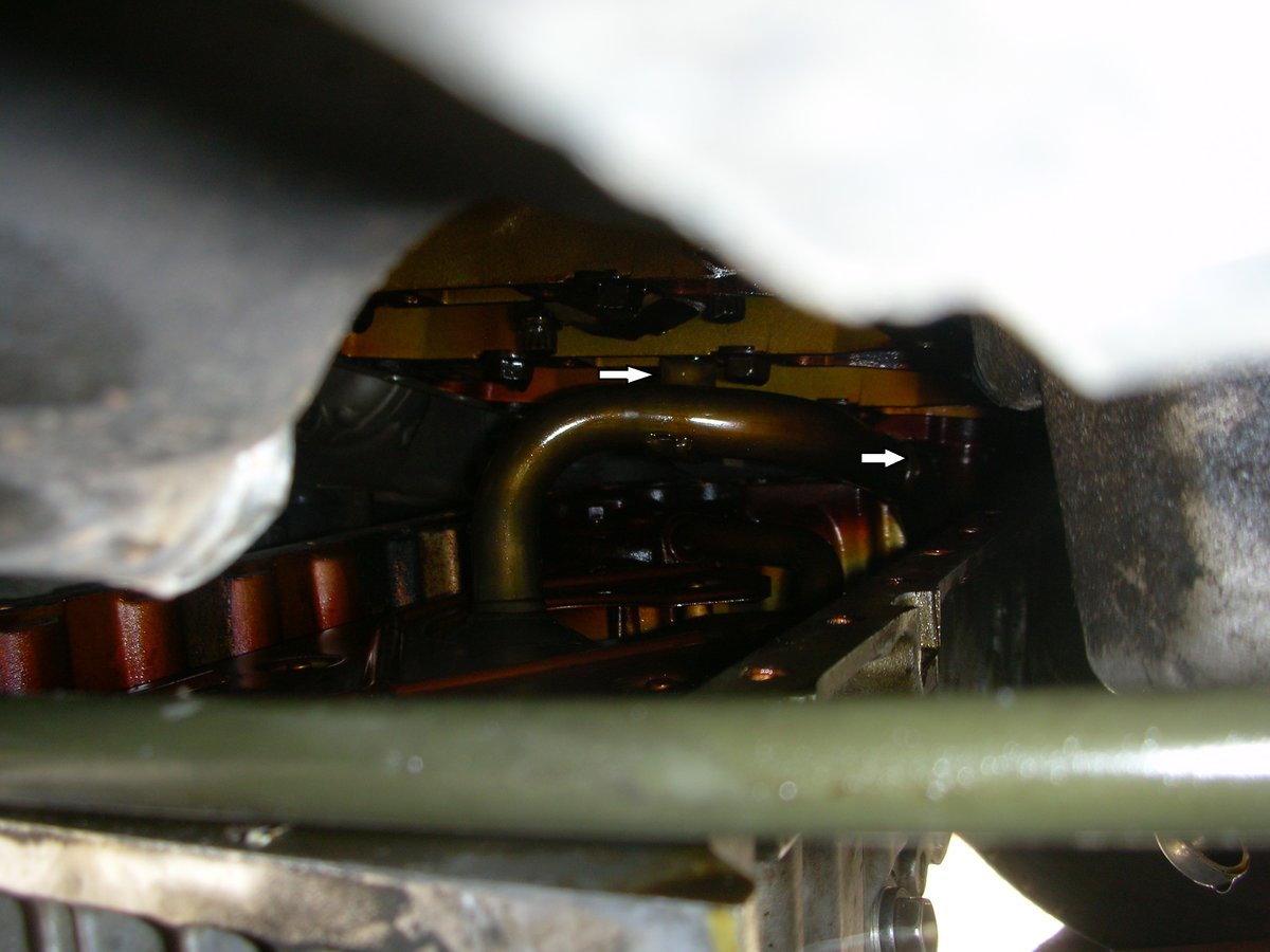 View inside from the driver's side, white arrows showing where the bolts are on the other side. Not easily accessible.