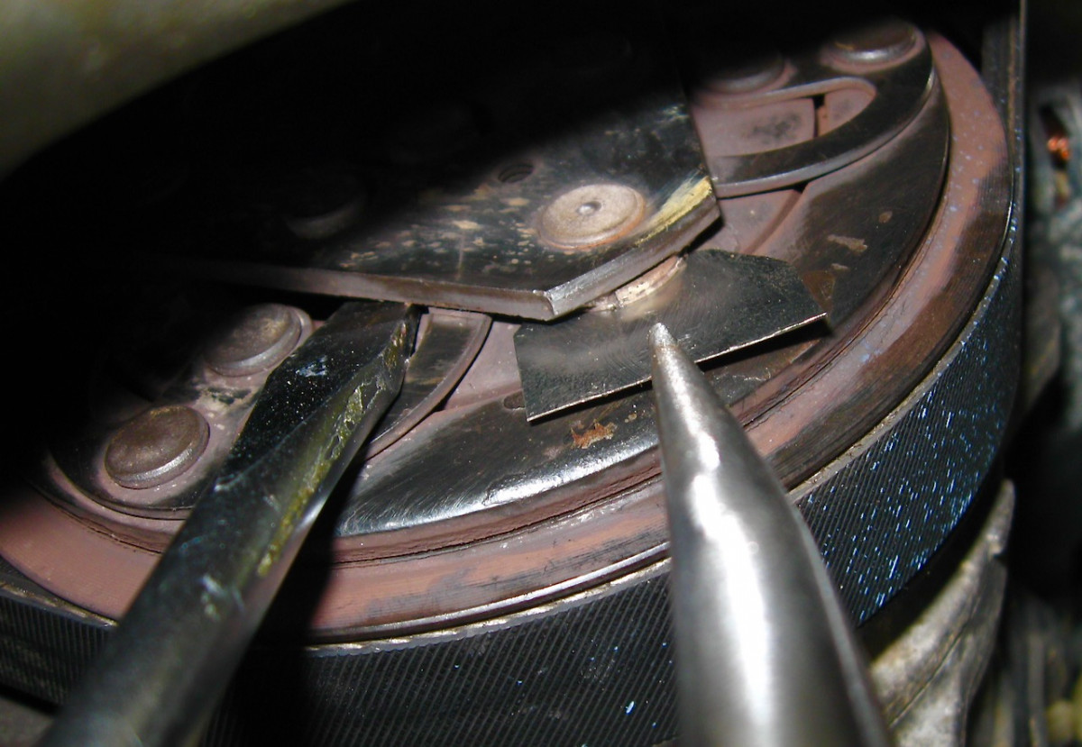 Opening the clutch with a screwdriver and sliding in a stainless shim under the bumper to tighten up the gap.