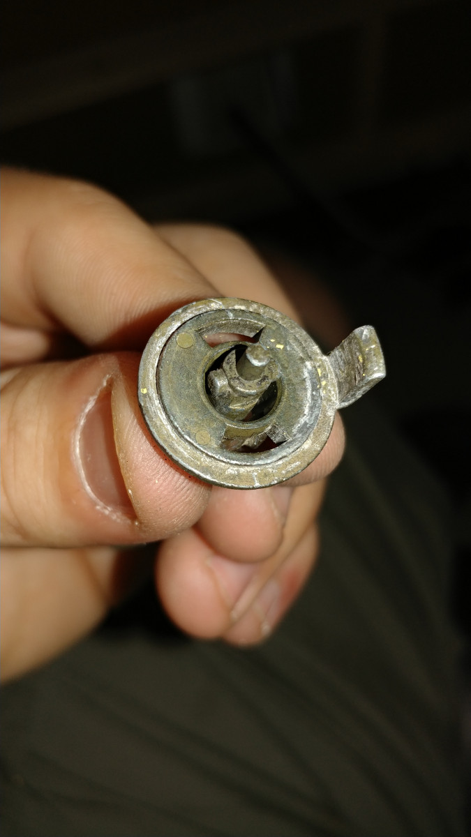 Rotate the rod 90° and completely pull it back through the metal hook thing and separate.