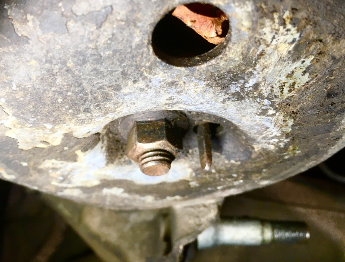 Threads, nut and tab on spring anchor, looking at the bottom of the spring seat.