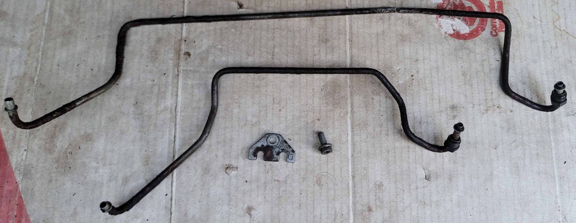 Power steering rack hydraulic lines, 12 mm nuts, retaining plate and TT27 bolt. Long line in two pieces.