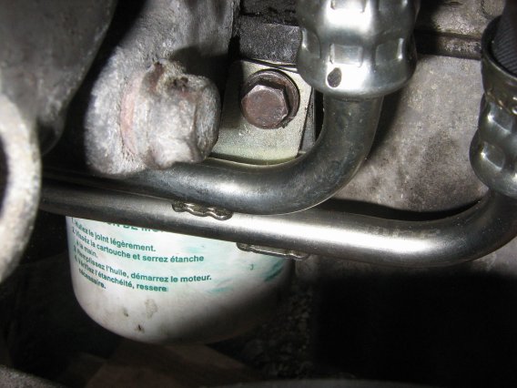 Oil cooler line bracket- note AC compressor bolt that partially blocks it.