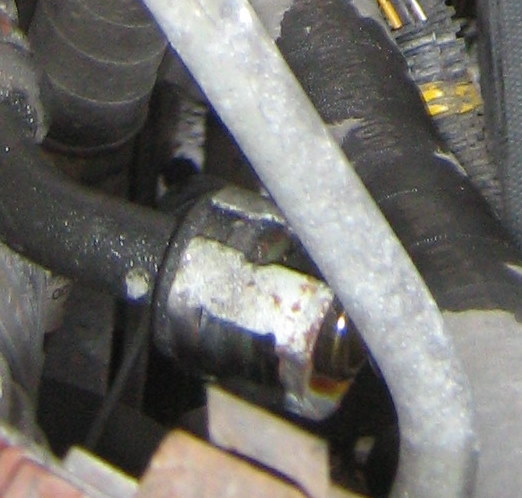 Shot at the end of one of the oil cooler hoses showing the clamp. Gently pry open the clamp and pull the line away from the rad.