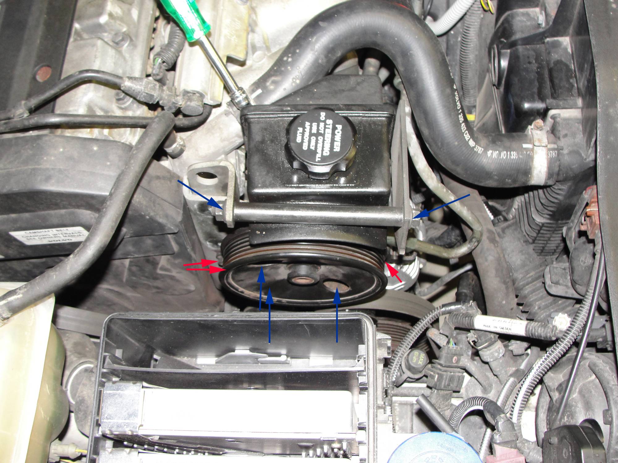 Red arrows are heads of three long bolts to be removed from passenger side.  Blue arrows show bolts to be loosened.  Electronics box lid and hose removed.