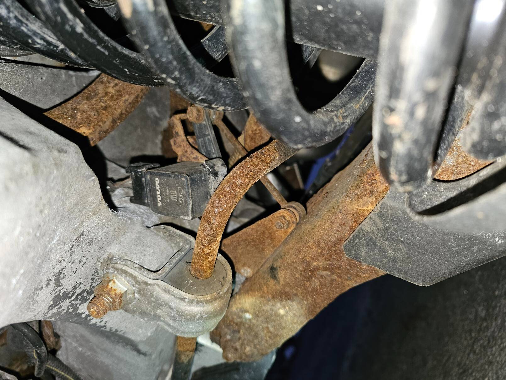 Two white spots within the paler area of rust are the two female fittings for screws from the triangular element of the linkage (that is seen resting on top of the suspension element that houses the fittings).