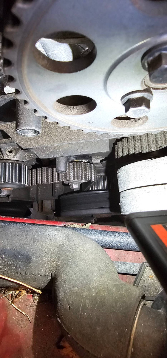 Look carefully at the tensioner to see the ring and the location of the broken flat piece of plastic shown in the first photo