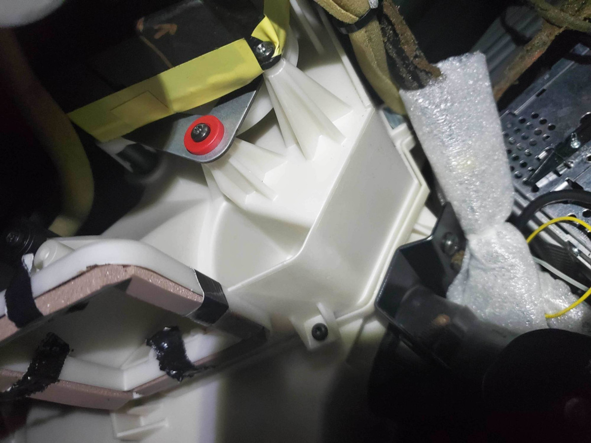 Now you can see the motor [yours won't have yellow tape].  One mounting Torx is visible.  Don't loosen the screw with red washer-- holding the flap lever.