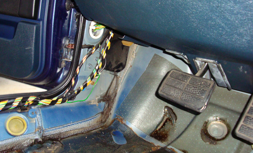 Look to the left of the break pedal to see the black panel. If you look below the black panel you can see a trail of water beneath it. What is the name of the black panel and can I seal it with silicon.